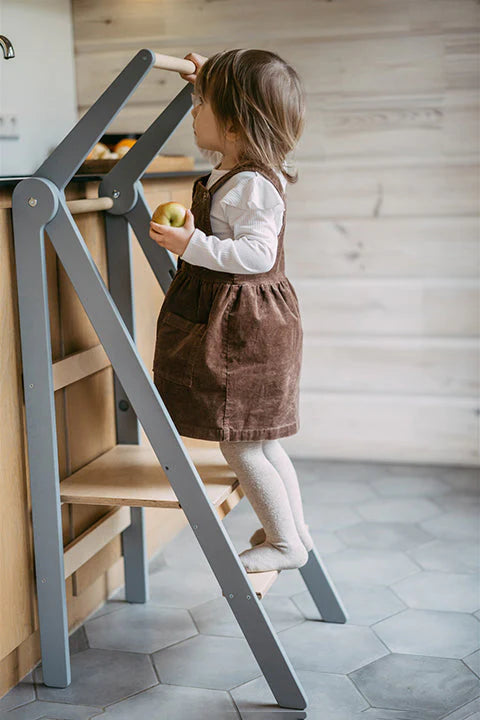 Petite fille debout sur les marches d'une tour d'observation 