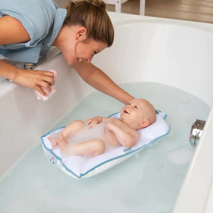 Un bébé allongé sur un matelas gonflé dans un bain moussant | Babykare.fr